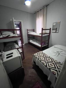 um quarto com duas camas e um par de beliches em casa de praia em Santos