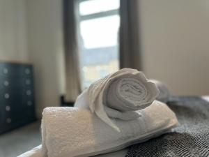 a white towel with a rose on a bed at Charming House - Perfect For Long Stays in Bishop Auckland