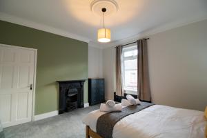 a bedroom with a bed with two white towels on it at Charming House - Perfect For Long Stays in Bishop Auckland