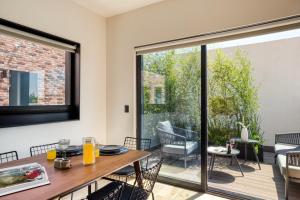 a dining room with a table and chairs and a large window at ULIV Roma Norte in Mexico City