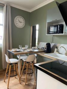 una cucina con tavolo, sedie e orologio sul muro di L'évasion Havraise a Le Havre