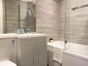 a bathroom with a toilet and a sink and a tub at Modern Stylish 2 bedroom 2 Bath Apartments in Rochester by 360Stays in Rochester