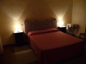 Un dormitorio con una cama con dos luces. en B&B Nonna Peppina, en Mògoro