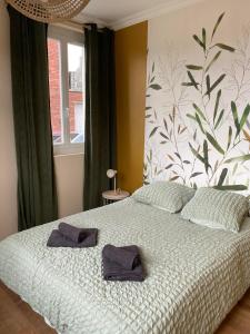 una camera da letto con un letto con due asciugamani sopra di L'évasion Havraise a Le Havre