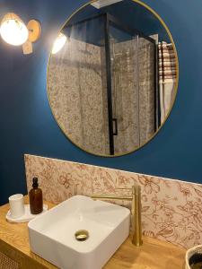 un bagno con un lavandino bianco e uno specchio di L'évasion Havraise a Le Havre