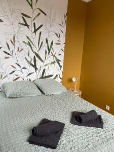 una camera da letto con un letto con due asciugamani sopra di L'évasion Havraise a Le Havre Altre 3 foto