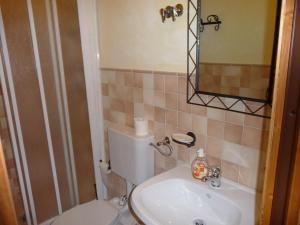 ein Badezimmer mit einem WC, einem Waschbecken und einem Spiegel in der Unterkunft B&B Nonna Peppina in Mògoro