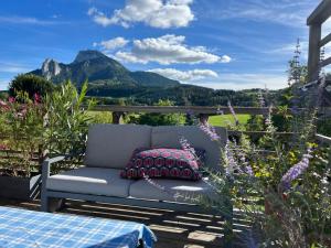 a couch sitting on a patio with mountains in the background at Huset på berget in Saint-Nizier-du-Moucherotte