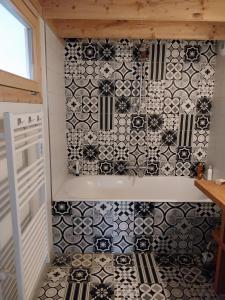a bathroom with a black and white tiled wall at Huset på berget in Saint-Nizier-du-Moucherotte