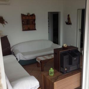 een kleine kamer met een bed en een televisie bij Traditional house with great view 90m from the sea in Salamis