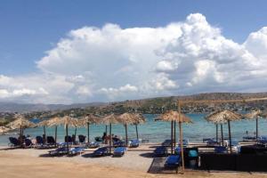 een groep stoelen en parasols op een strand bij Traditional house with great view 90m from the sea in Salamis