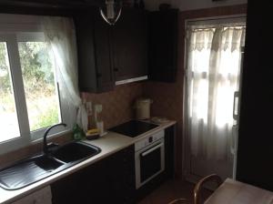 uma pequena cozinha com um lavatório e uma janela em Traditional house with great view 90m from the sea em Salamís