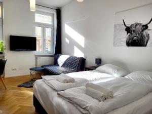 - une chambre avec 2 lits et une photo de vache sur le mur dans l'établissement Kienmayer Apartment Vienna, à Vienne