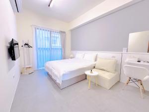 una camera bianca con letto e scrivania di 一玖玖一民宿 1991 a Magong