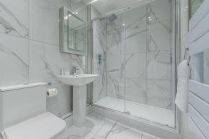 a white bathroom with a shower and a sink at The Fairytale - Fitzrovia - by Frankie Says in London