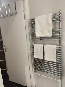a towel rack in a bathroom with white towels at La Maison de l Echauguette Petit Dejeuner et Menage Offerts in Clermont-Ferrand +17 photos