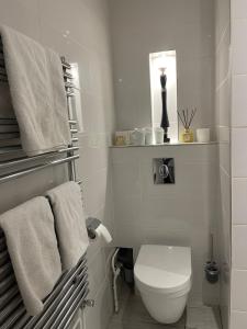 une salle de bain blanche avec toilettes et serviettes dans l'établissement La Maison de l Echauguette Petit Dejeuner et Menage Offerts, à Clermont-Ferrand 21 autres photos