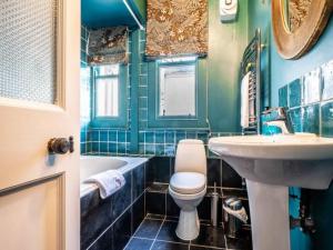 a bathroom with a sink and a toilet and a tub at Pass the Keys Garden View Period Dartmoor apartment with garden views in Chagford