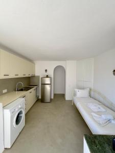 a kitchen with a bed and a washer and dryer at Cielo Azul Mykonos in Mýkonos City
