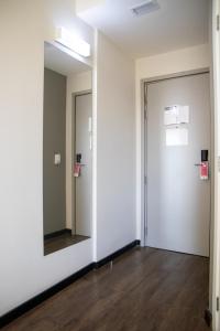 an empty room with a mirror and a door at ibis Styles Tres Rios in Três Rios