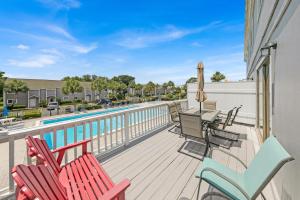 a deck with chairs and a swimming pool at Southbay by the Gulf 11 a 4 Bedroom Townhome with Beach Access and 300ft of Private Beach in Destin
