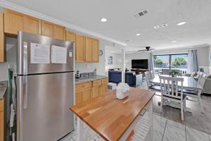 a kitchen with a stainless steel refrigerator and a table at Southbay by the Gulf 11 a 4 Bedroom Townhome with Beach Access and 300ft of Private Beach in Destin
