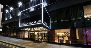 una tienda frente a un edificio por la noche en Sandman Signature Glasgow Hotel, en Glasgow