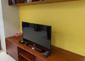 einen Flachbild-TV auf einem Holztisch in der Unterkunft Lasalle Park Serviced Apartment at Lasalle 75 in Bangna