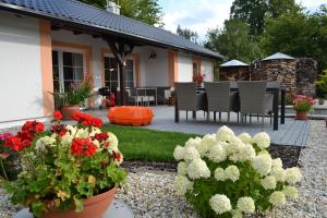 einen Garten mit Blumen in Töpfen und eine Terrasse in der Unterkunft Ubytování Slezská Harta 
