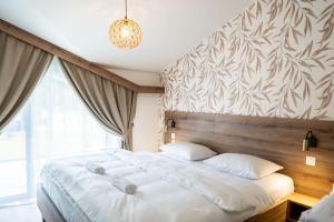 a bedroom with a large white bed with a wooden headboard at Apartmány Hájenka Oravice in Oravice