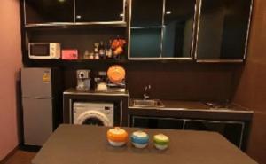 a small kitchen with a table with cupcakes on it at Lasalle Park Serviced Apartment at Lasalle 75 in Bangna