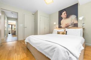 a bedroom with a large bed with a large painting on the wall at Sophia Gardens Apartment in Cardiff