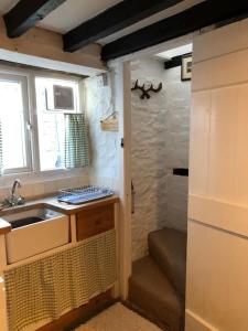 a small kitchen with a sink and a window at Lavender Cottage, 3 School Road, Clun, Shropshire in Clun