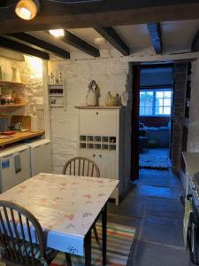 a kitchen with a table and a table and chairs at Lavender Cottage, 3 School Road, Clun, Shropshire in Clun