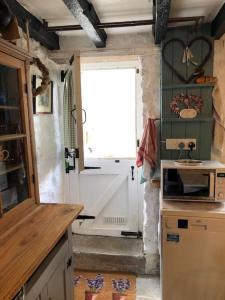 a kitchen with a window and a sink and a stove at Lavender Cottage, 3 School Road, Clun, Shropshire in Clun