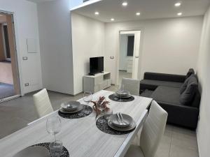 a living room with a table with plates and wine glasses at SOLUZIONE CASA Pietra Ligure SEA HOUSE in Pietra Ligure