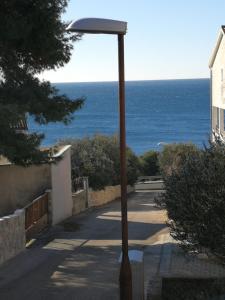 a street light with the ocean in the background at HOUSE Kod dide in Primošten