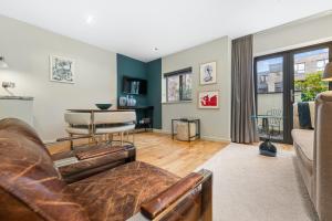 a living room with a couch and a table at Sophia Gardens Apartment in Cardiff