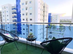 a balcony with two chairs and a table at Family Fun Vacation In Paradise in Santiago de los Caballeros