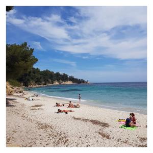 un grupo de personas tumbadas en una playa en Le Mas de la Palmeraie - Mas 3 dans propriété privée au calme avec piscine et tennis, en Bormes-les-Mimosas