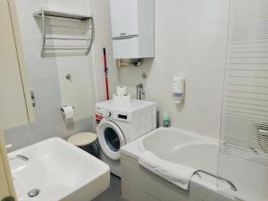 a white bathroom with a washing machine and a sink at Nova Galerija West App Mary in Zagreb