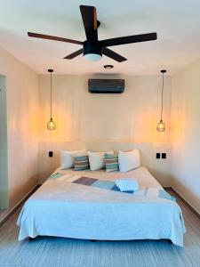 a bedroom with a large bed with a ceiling fan at Hotel Caracol Isla Mujeres in Isla Mujeres