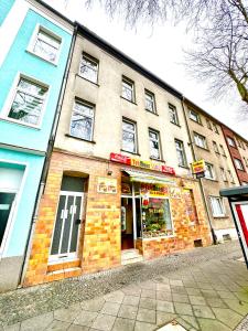 un edificio de ladrillo con una tienda en una calle en Frisch renoviert, Dschungel Apartment, 4 Betten, Smart TV, Sonos, nahe Messe Düsseldorf, Helios Klinik, Innenstadt, en Krefeld