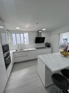a white kitchen with a sink and a counter at Apartamento Belo Horizonte in Funchal
