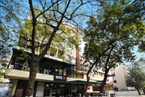 a building with trees in front of it at Hotel O Crystal in Ahmedabad