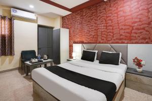 a bedroom with a large bed and a red wall at Flagship Hotel Crystal in Ahmedabad