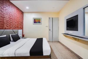 a bedroom with a large bed and a flat screen tv at Flagship Hotel Crystal in Ahmedabad