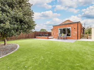 a garden with a brick house with a lawn at 2 Bed in Mablethorpe 93143 in Trusthorpe
