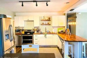 a kitchen with white cabinets and a wooden counter top at Eagles Beach Nest II in New Buffalo