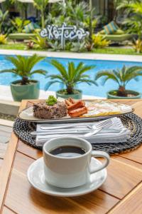 un plato de comida y una taza de café sobre una mesa en Exôtico Beach Hotel, en Puerto Viejo
